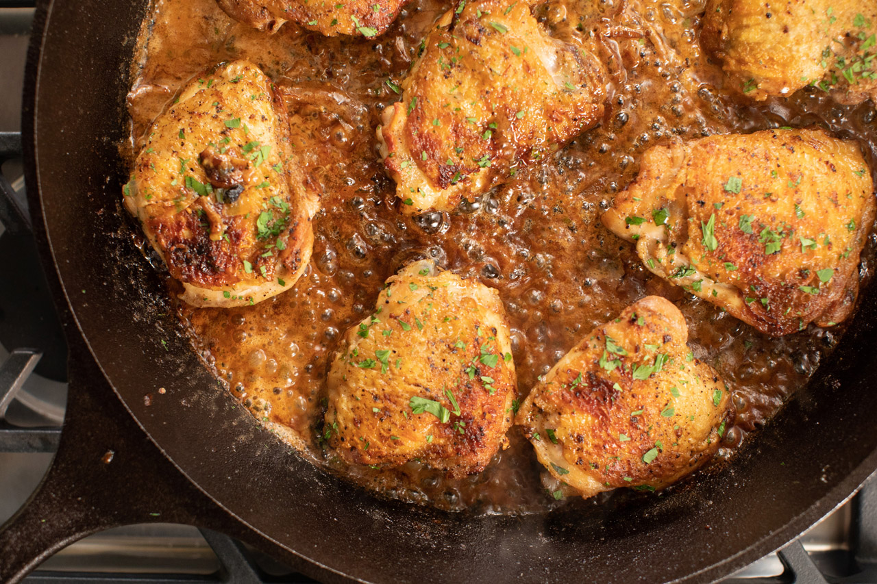Chicken thighs with a creamy mustard sauce in a cast iron skillet