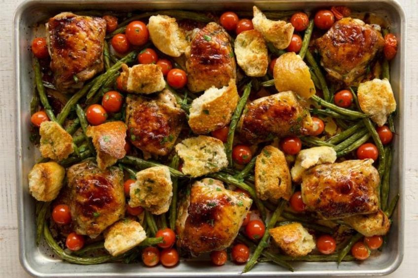 An Italian sheet pan supper with green beans, cherry tomatoes, bread and chicken thighs