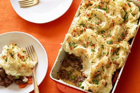 shepherd's pie on table with creamy mashed potatoes on top in casserole dish