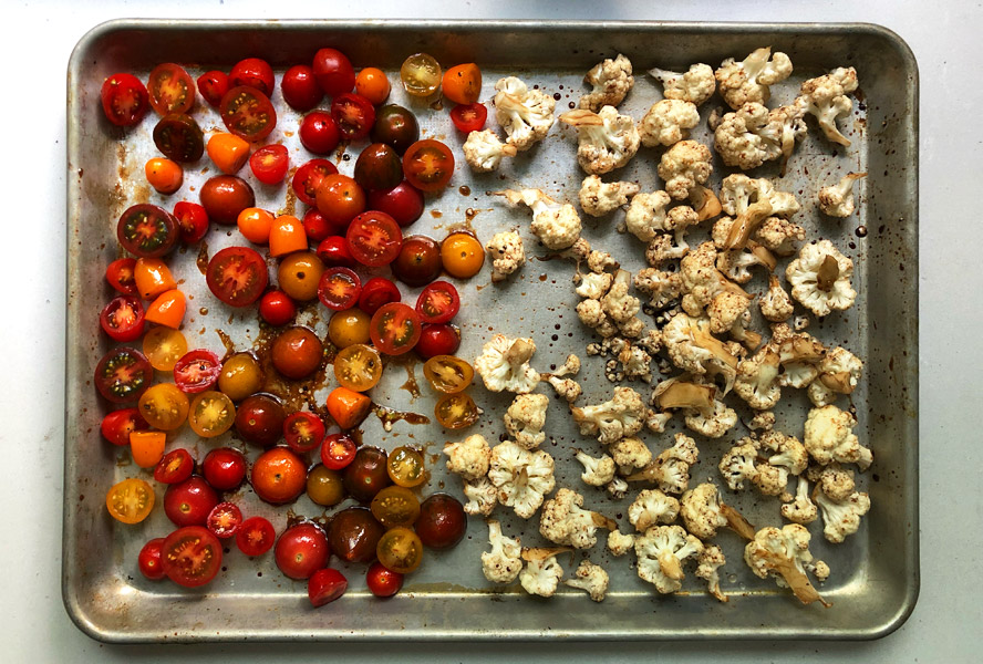 tomatoes and cauliflower on a baking tray