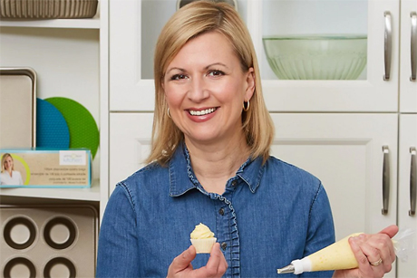 Anna Olson smiles while icing a cupcake with her Anna Olson Kitchen Disposable Icing Bags