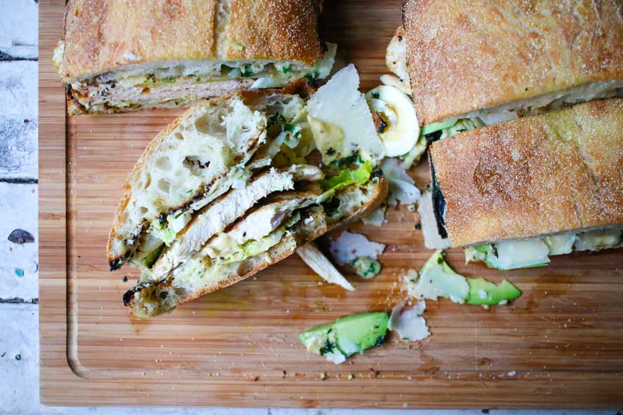 Best-Ever Grilled Chicken Caesar Salad Sandwich on a wooden cutting board