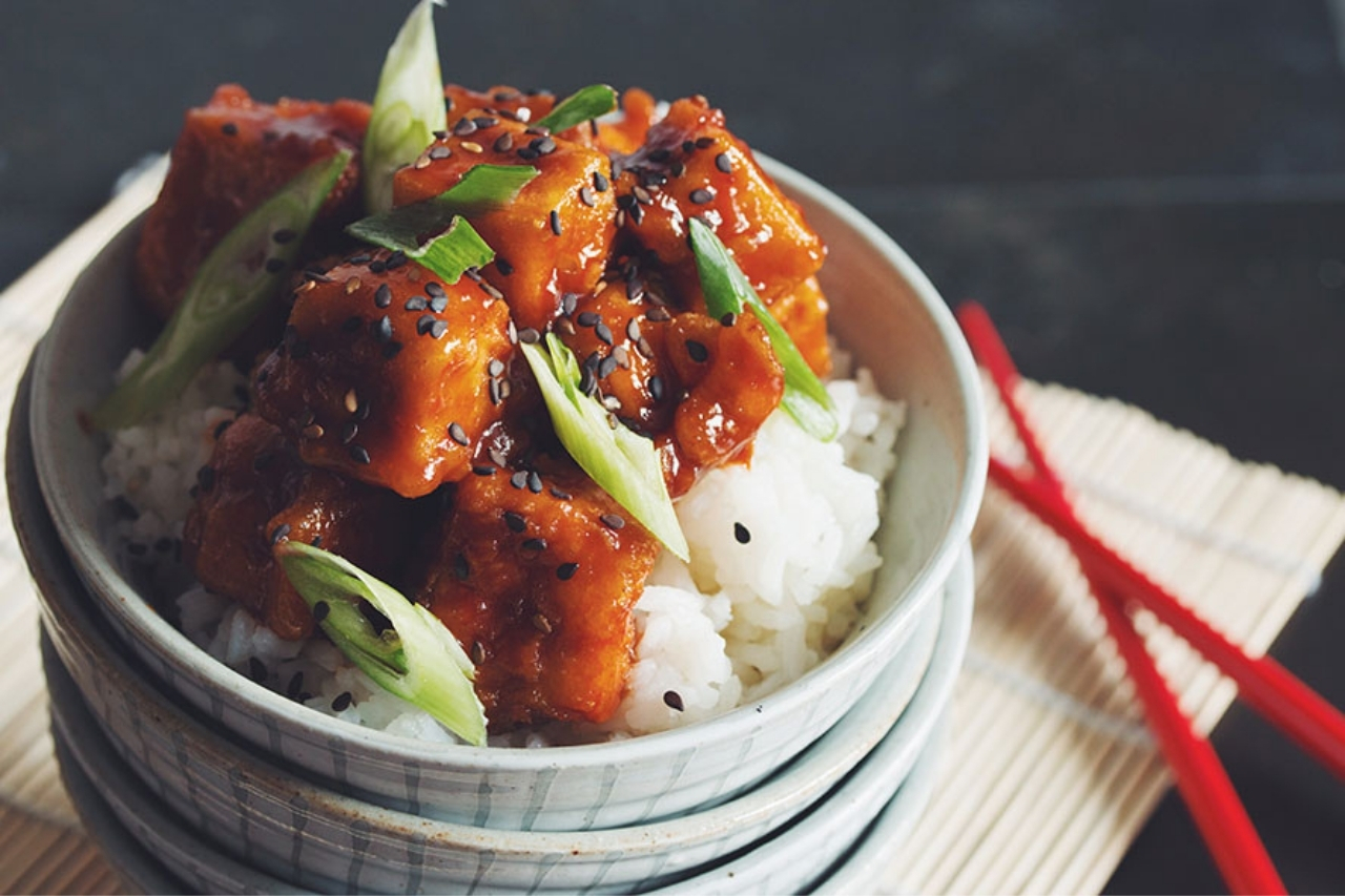 A bowl of crispy tofu with sweet and source sauce and rice