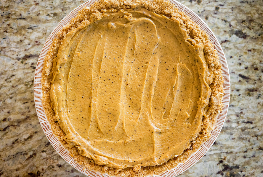 Pumpkin pie mixture being spread over crust