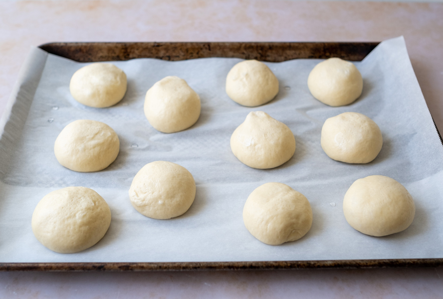 Mini bagel dough balls on parchment lined cookie sheet