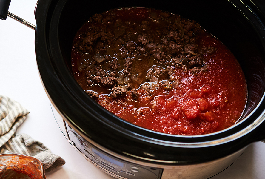 tomatoes and beef in a slow cooker for slow cooker bolognese