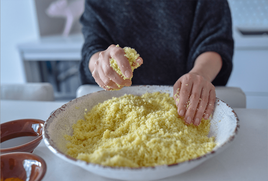 lifting couscous grains in a bowl