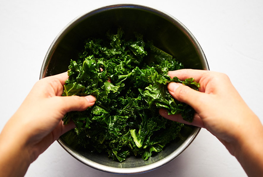 massaging kale in a bowl
