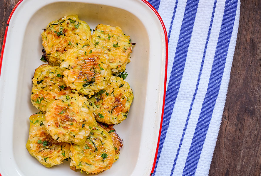 zucchini and corn fritters lined on a tray