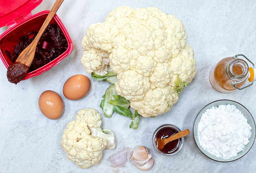 Mise en place with gochujang sauce, cauliflower, eggs, garlic, honey and vinegar