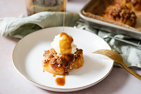 Hasselback apple with scoop of vanilla ice cream and drizzling of toffee sauce