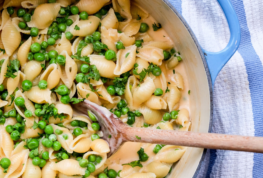 cheesy one pot pasta with peas in a dutch oven