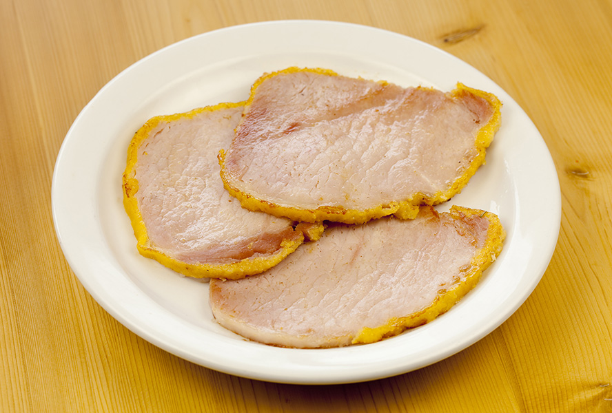 White plate with three pieces of peameal bacon