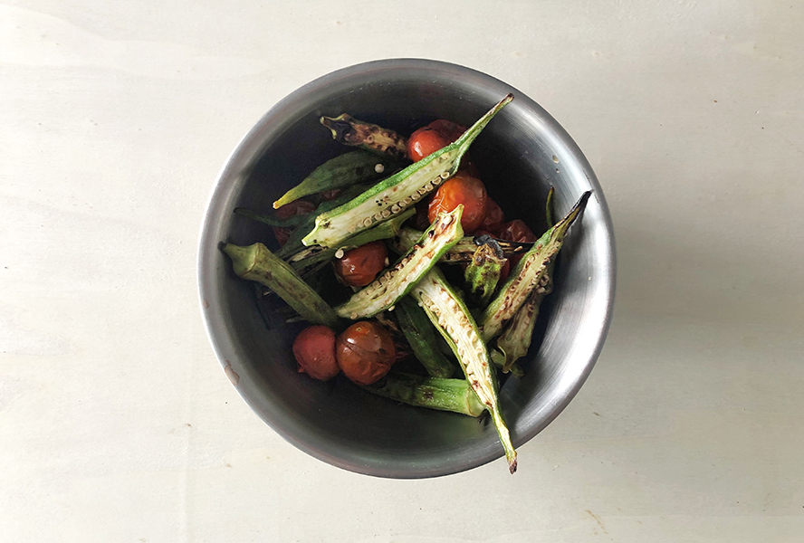 Bowl of charred okra, tomato and steak salad ingredients