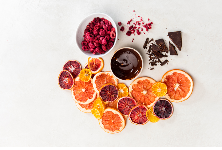 Rich chocolate ganache in a bowl with dried fruits and citrus