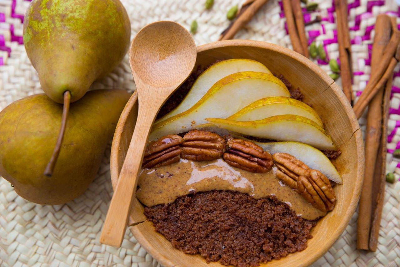 a teff breakfast bowl with a pear on the side