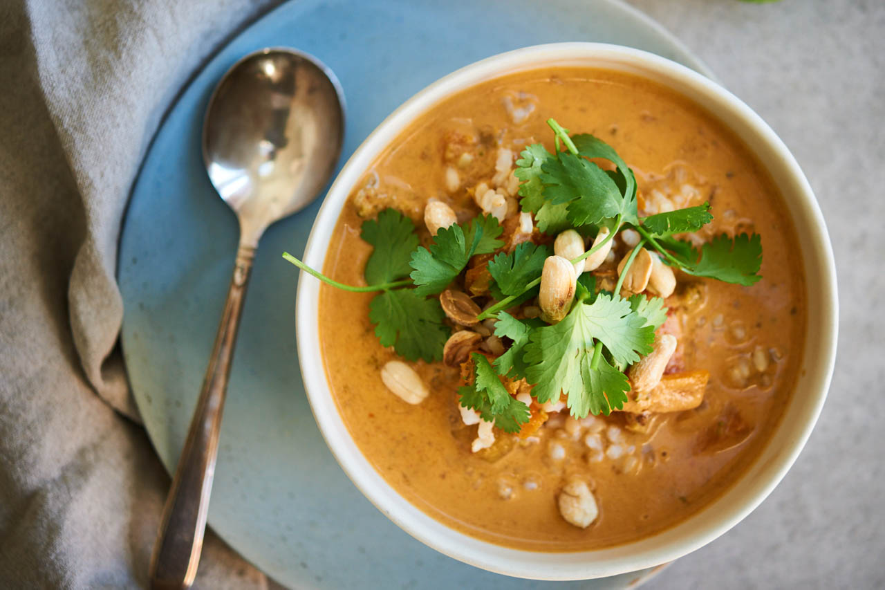 slow cooker thai red curry soup in a white bowl topped with cilantro