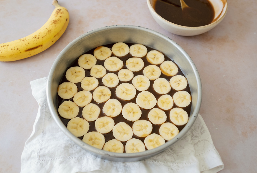 Banana upside down cake with toffee on the bottom of the pan and sliced bananas on top