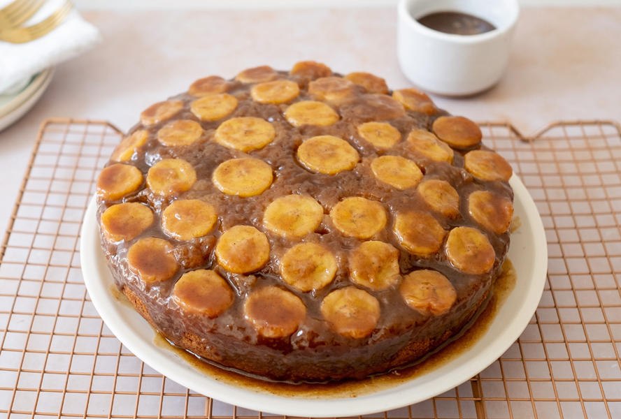 Banana upside down cake with toffee topping cooling on a wire rack