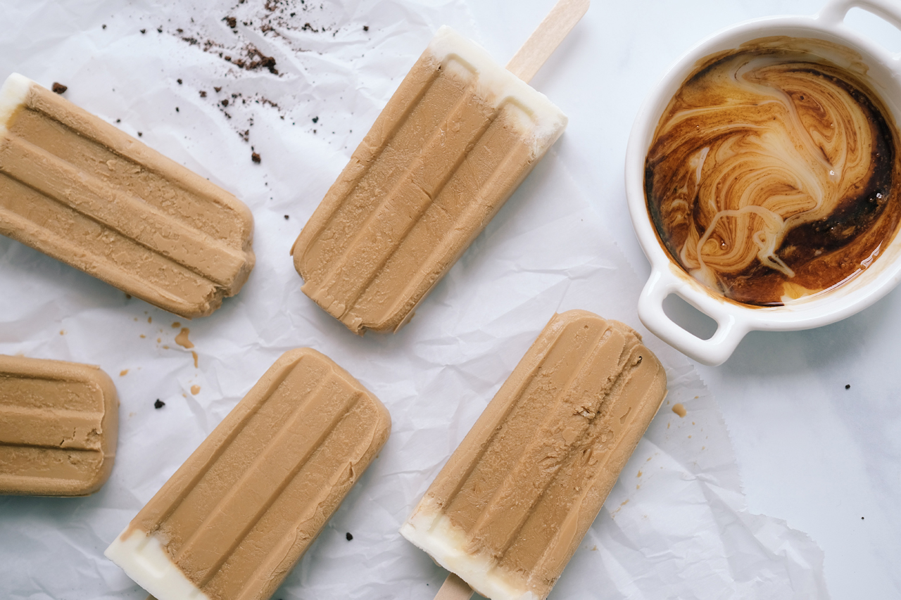 Vietnamese coffee popsicles with a hot mug of coffee