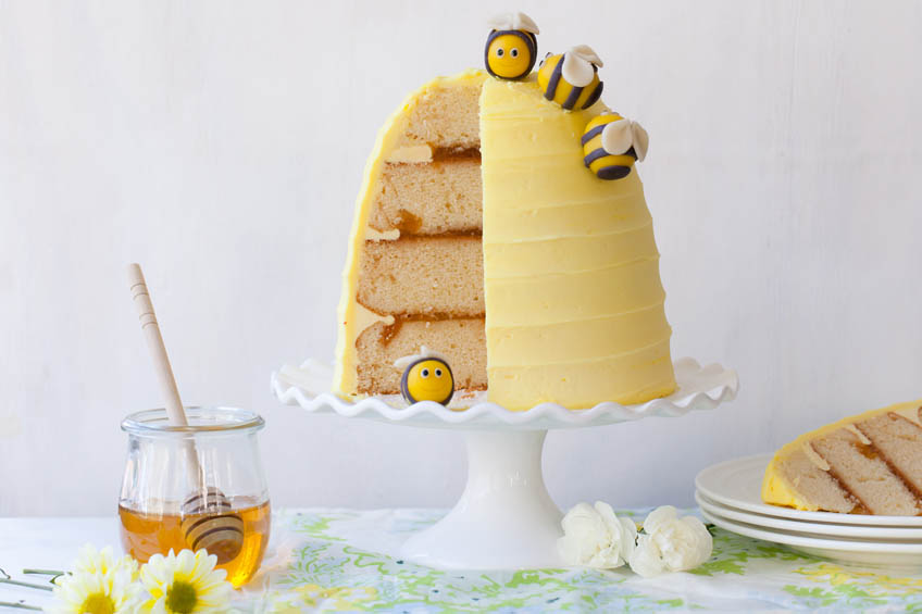 Bee-utifully Sweet Spring Honey Cake shaped like a honeycomb on a white pedestal plate