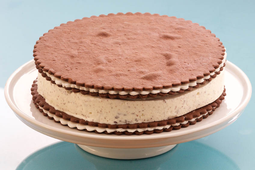 A massive round ice cream sandwich cake on a white pedestal plate