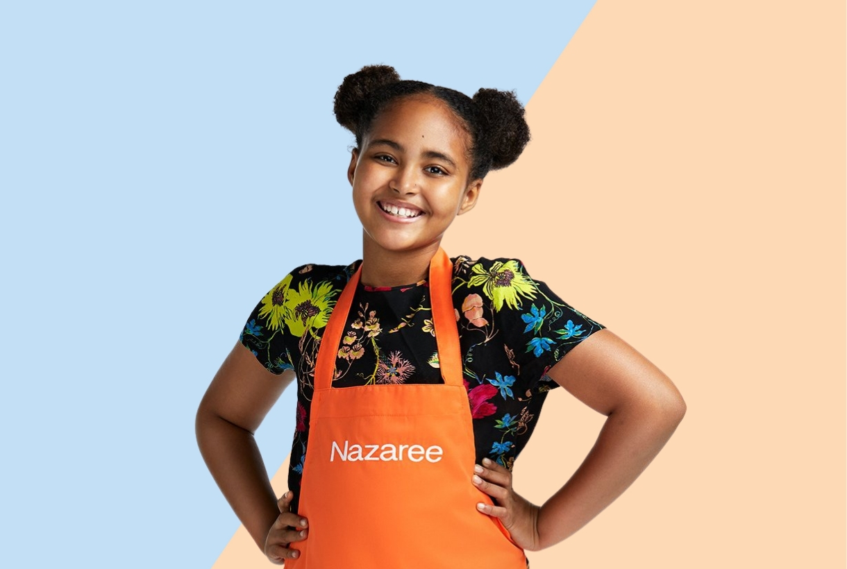 Smiling Chef Nazaree in an orange apron and floral blouse