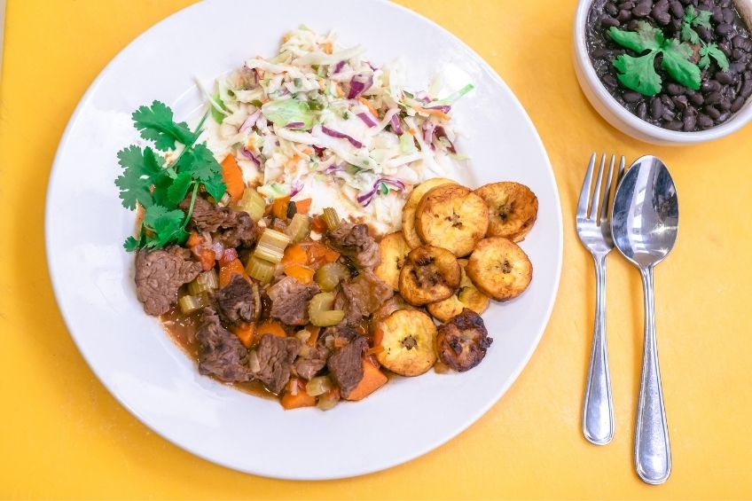 beef with plantains on white plate