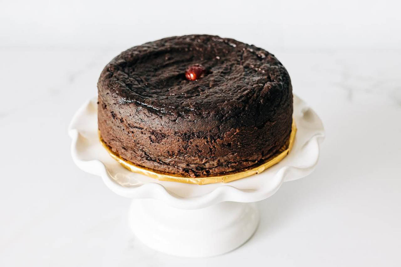 Neale's Sweet N' Nice Black Cake on a pedestal