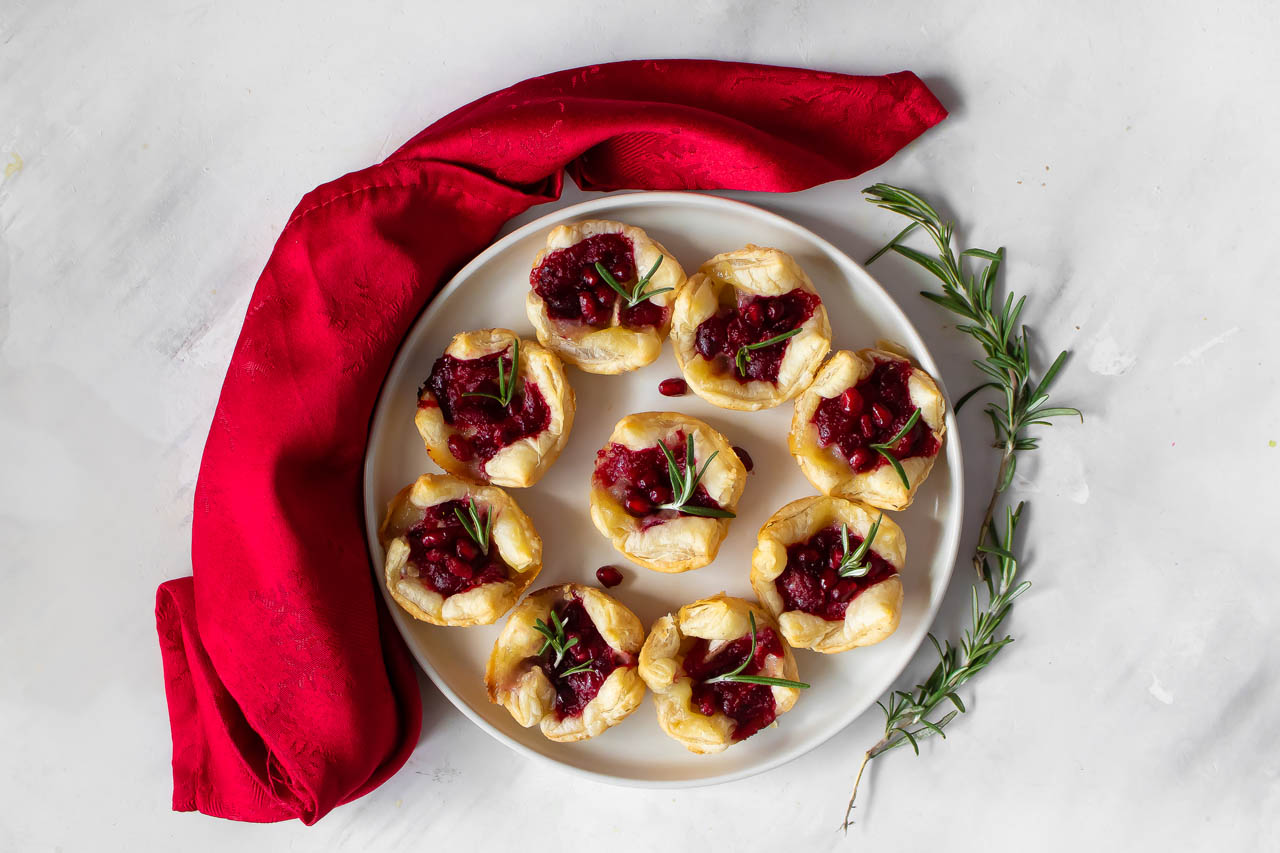 Cranberry, Camembert and Pomegranate Bites on a white plate
