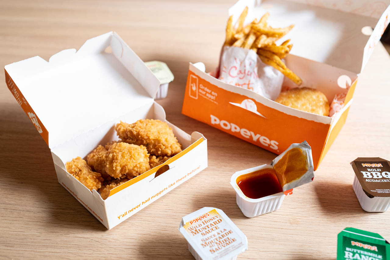 A box of Popeyes nuggets on a wooden tabletop
