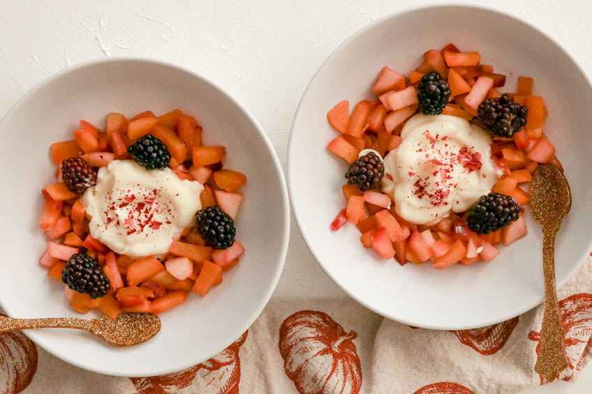 2 bowls of fruit salad with rose custard on a white countertop