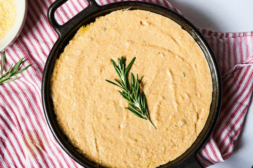 batter for vegan cornbread with rosemary and maple in a cast iron skillet