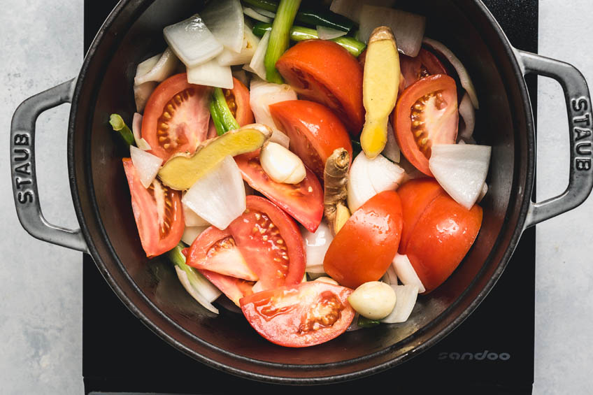 tomatoes, onion, garlic, ginger and white parts of scallion being sauteed in a pot