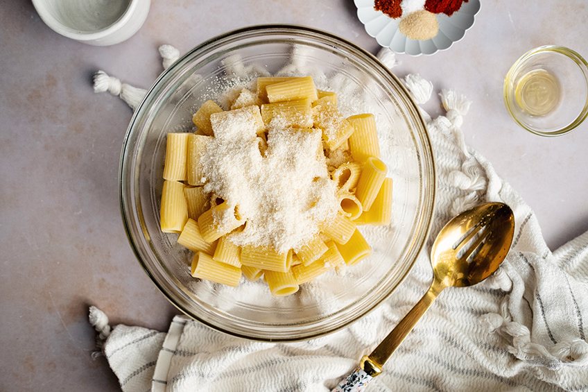 cooked rigatoni pasta in a bowl with parmesan on top