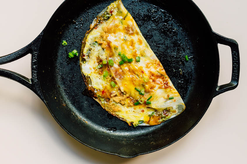 a folded Vietnamese pizza in a cast-iron skillet