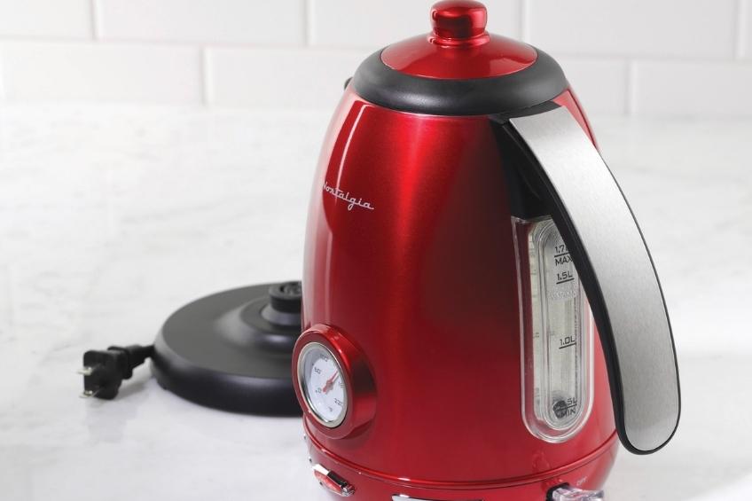 A retro red kettle on a white countertop.
