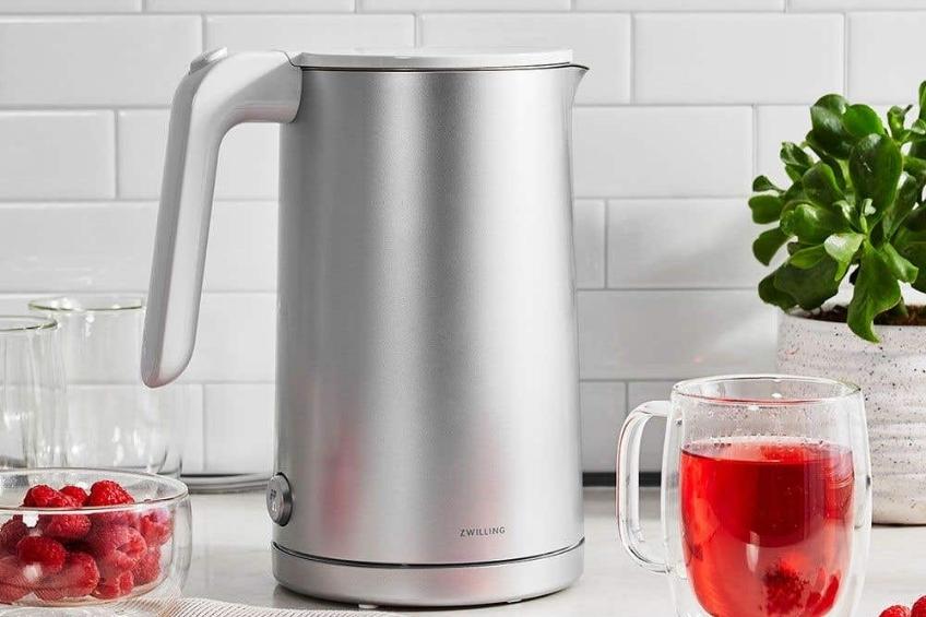 A chrome electric tea kettle on a white counter.