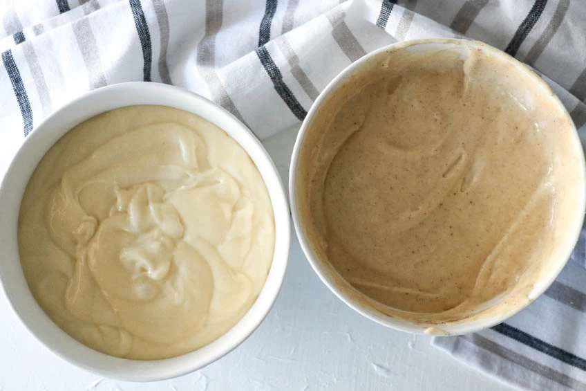 2 mixing bowls, 1 of vanilla bean pound cake batter and 1 of gingerbread spiced pound cake batter