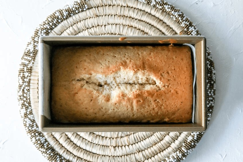 A baked loaf of gingerbread spiced pound cake in the baking pan