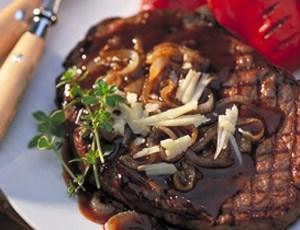 Grilled Rib Eye Steak with Canadian Cheddar and Roasted Onion Sauce