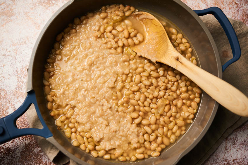 White beans in a skillet for brothy, herby white beans