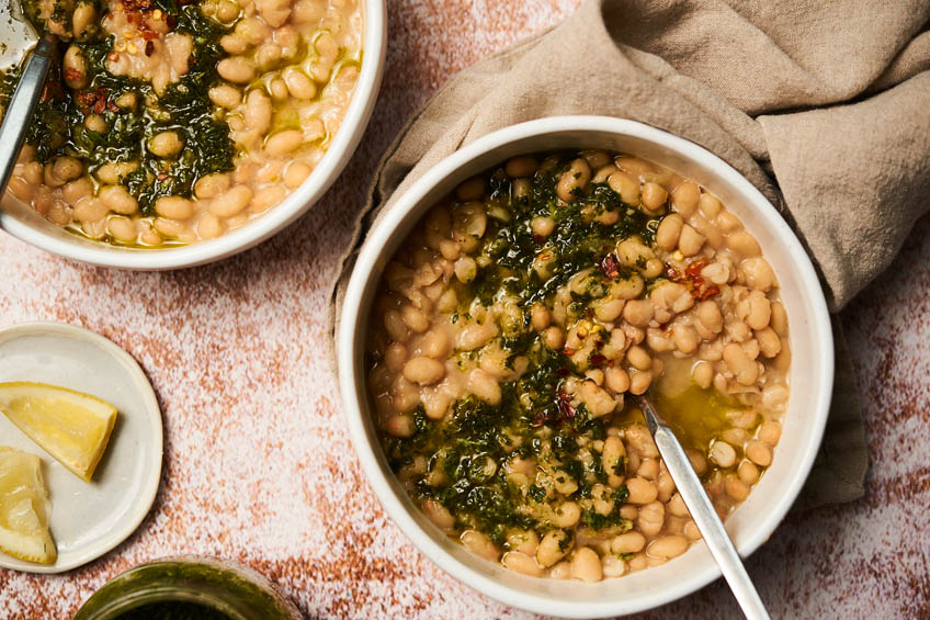 A bowl of brothy beans with herbs