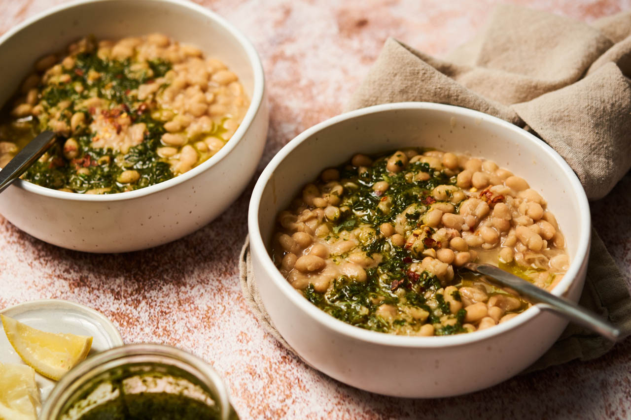 A bowl of brothy beans with herbs