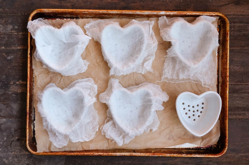 Heart-shaped molds lined with cheesecloth