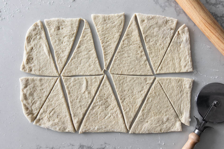 Pizza dough cut into triangles for Hawaiian pigs in a blanket