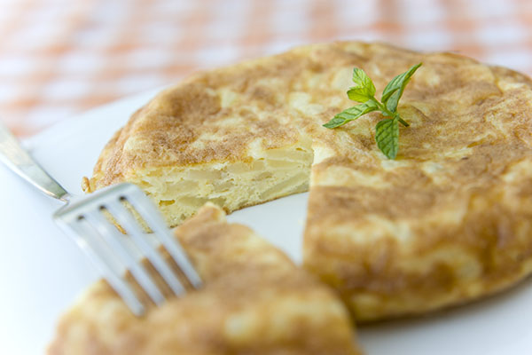 Spanish potatoe and onion omelette on plate with fork.