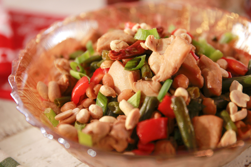 Kung pao chicken made with green beans, bell pepper and peanuts, and served in a glass bowl