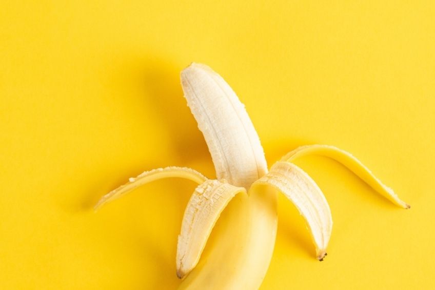 Peeled banana on a yellow background