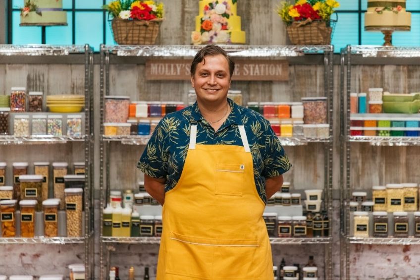 A portrait of Romuald in a yellow apron.